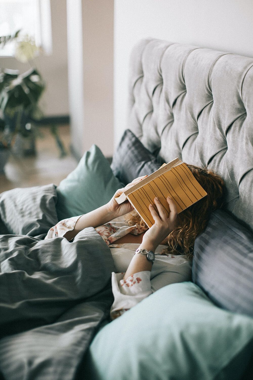 woman-covering-face-with-book-on-bed-1524232.jpg